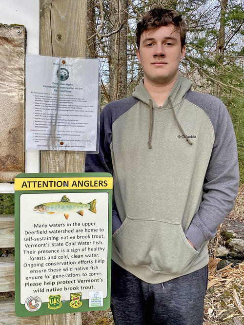 Noah Wein Volunteer Noah Wein with a sign highlighting the presence of wild native brook trout in the upper Deerfield watershed.
